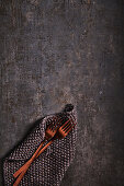 Copper-coloured cutlery, crocheted cloth on a metal background