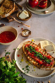 Gegrillte Bruschetta mit Tomaten, Petersilie und Käse