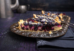 Vegan cheese tart with blackcurrants and almonds
