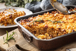 Pasta casserole with smoked meat, sausage, egg, cheese and herbs