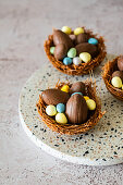 Easter nest made from vermicelli and melted chocolate filled with Easter eggs