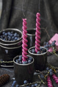 Kerzenständer mit frischen Schlehenbeeren gefüllt