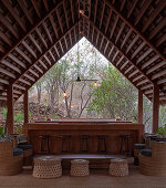 Interior view of a palapa with wooden beamed ceiling and open view in Mazunte, Mexico