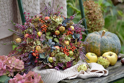 Colourful autumn wreath with hydrangea, heather, ornamental apples and rowan berries