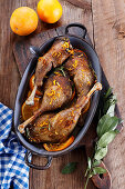 Roast duck legs with orange slices and herbs