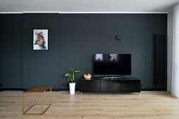 Modern, minimalist living room design with dark walls
