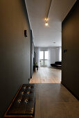 Hallway with dark painted walls and bench, transition to the living room