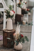 Floral decoration on wooden stumps with eucalyptus branches and roses