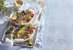 Baked trout en papillote with vegetables and herbs