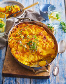 Potato casserole with pumpkin and cheddar sauce and thyme