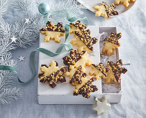 Snowflake-shaped biscuits with chocolate icing and nuts