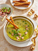 Erbsensuppe mit Speckwürfeln und knusprigen Brotstangen