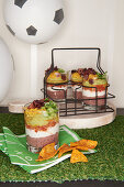 Seven layer dip made from bean puree, yoghurt, tomatoes, avocado and cheese