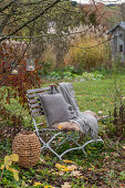 Sitzplatz im herbstlichen Garten mit Windlichtern im Baum hängend