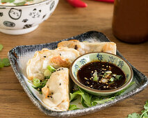 Fried gyoza with soya sauce and spring onions