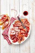 Italian sausage and ham platter with bread and wine