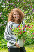 Frau mit Blumenstrauß aus Inkarnat Klee (Trifolium incarnatum) und Gräsern