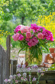 Strauß aus Pfingstrosen (Paeonia) auf Gartentisch