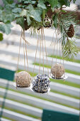 Upcycling Fat ball holder made from a metal drain sieve hanging from a beam in the garden, DIY