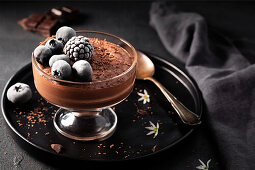 Mousse au Chocolat mit Schokoladenspänen und dunklen Beeren