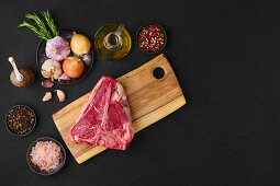 Raw porterhouse steak with spices and garlic