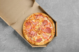 Pizza with ham, salami and tomatoes