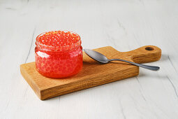 Salmon caviar in a jar with spoon