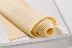 Fresh, rolled pasta dough on a floured board