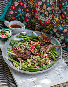 Lammkoteletts mit Freekeh, Thai-Spargel und Granatapfelkernen