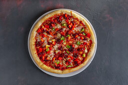 Pizza with peppers, ham and caramelised vegetable sauce