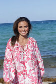 Woman in floral tunic on the beach