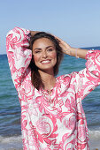 Woman in floral tunic on the beach