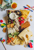 Cheese platter with vegetables, crackers and fruit snacks