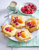 Blätterteiggebäck mit Aprikosen, roten Beeren und Vanillepudding