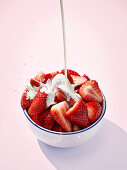 Pour cream over strawberries