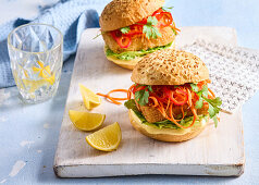 Fish burger with marinated carrots, peppers and coriander