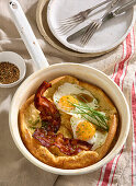 Dutch baby pancake with bacon and fried eggs