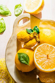 Whole and sliced lemons with basil