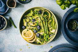 Salad with zucchini, asparagus, cucumber, peas and blueberries