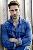 Man in denim shirt, arms crossed