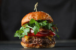 Bacon cheeseburger with tomatoes and rocket