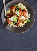 Spiced chicken meatballs in tomato sauce on couscous