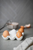 Fresh eggs in an egg carton, cracked egg