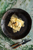 Raviolo filled with egg yolk and melted butter