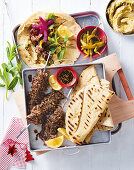 Beef kebabs with Aleppo pepper, flatbread and chilli coriander hummus