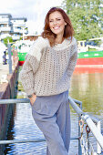 Rothaarige Frau in braun-beigem Strickpullover mit Lochmuster