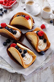 Biscuit tacos with cream filling and fresh berries
