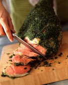 Carving a leg of lamb with herbs