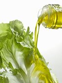 Pouring olive oil onto a lettuce leaf
