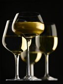 Composition with glasses of white wine on a black background